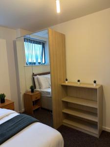 ein Schlafzimmer mit einem Spiegel, einem Bett und einem Fenster in der Unterkunft City Centre 2 Bed Room 2 Bath Room Apartment with En-suite in Liverpool