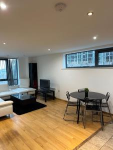 ein Wohnzimmer mit Tisch und Couch in der Unterkunft City Centre 2 Bed Room 2 Bath Room Apartment with En-suite in Liverpool