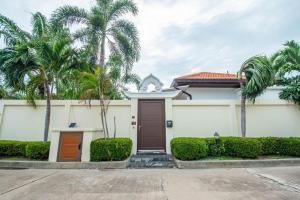 una casa con delle palme davanti di Private Pool 3B villa Snooker Karaoke Beach 200m a Pattaya Sud