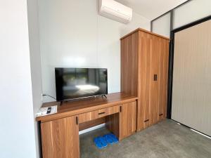 una TV a schermo piatto seduta sopra un centro di intrattenimento in legno di Thanh Bình Homestay a Nha Trang Altre 14 foto