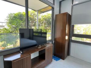 una TV a schermo piatto in una camera con finestre di Thanh Bình Homestay a Nha Trang