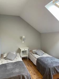 two beds in a white room with a table at VillaAnita in Augustów +29 photos