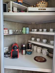 a shelf with cups and bowls and a red blender at Mountain Lake View Deluxe in Saint-Cergue +15 photos