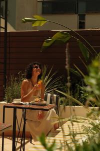 a woman sitting at a table eating food at Astikon House in Athens +63 photos