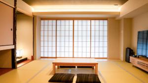 a living room with a table and a large window at Tabist kiki HOTEL KYOTO Gojo Karasuma in Kyoto