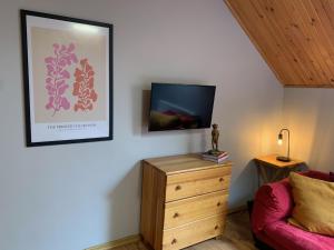 a living room with a tv and a wooden dresser at VillaAnita in Augustów
