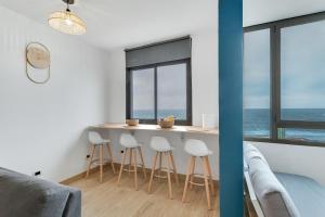 a room with a counter with stools and a table with the ocean at Casa Adrimar in Cabo Verde