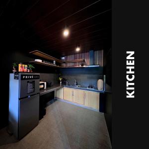 a kitchen with a black refrigerator and wooden cabinets at Privé Cabin in Bacolor