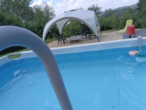 a swimming pool with a tent and a gazebo at Camera Glicine con bagno privato in Castellero