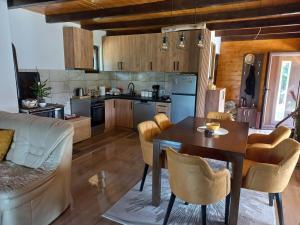 a kitchen and living room with a table and chairs at Apartmani Nase brdo in Guča