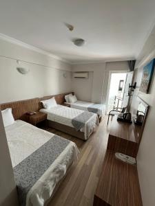 a hotel room with two beds and a window at Hotel Cenka Ephesus in Selçuk
