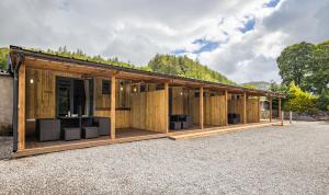 a large wooden building with a lot of windows at Cosy Glamping In the Eskdale Valley - Studio Lodges and Mega Pods in Eskdale
