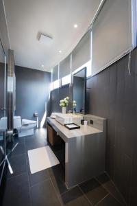 a bathroom with a sink and a mirror and a toilet at Hotel Reve Taichung in Daya