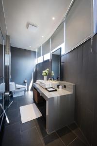 bagno con lavandino, specchio e servizi igienici di Hotel Reve Taichung a Daya