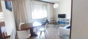 a living room with a table and chairs and a window at Dalla Torre al mare in Cervia