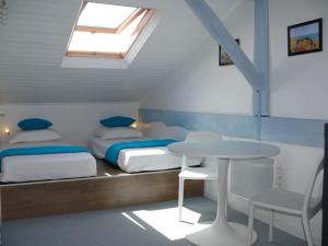 a bedroom with two beds and a table and a window at Infinity View Bidart in Bidart