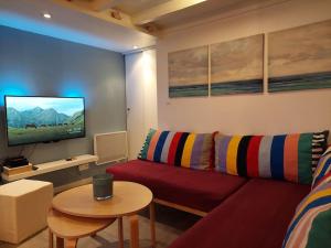 a living room with a red couch and a table at Infinity View Bidart in Bidart