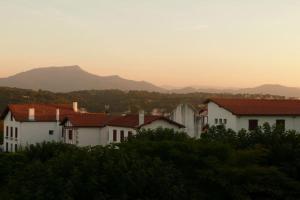 a group of white houses with mountains in the background at Infinity View Bidart in Bidart