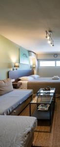 a hotel room with two beds and a table at Pol's studio, Kalamata Mediterranean Apartments in Kalamata