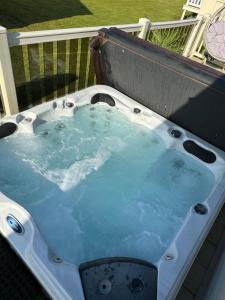 a jacuzzi bathtub with blue water in it at Hot tub retreat at Tattershall Lakes in Tattershall
