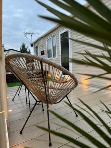 a bench sitting on a deck next to a house at Hot tub retreat at Tattershall Lakes in Tattershall