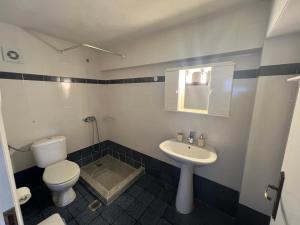 a bathroom with a toilet and a sink at Galini 1 in Kalamata +6 photos