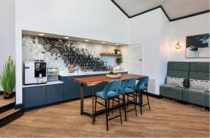 a kitchen with a wooden table and blue chairs at Wyndham 219 Modern 2br Suite, Parking in Hampton