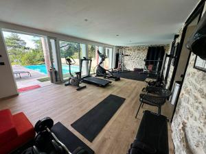 a gym with treadmills and exercise equipment in a room at LA MAISON DE ROBINSON in Le Plessis-Robinson