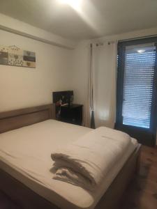 una camera da letto con un letto bianco con una finestra di Location maison avec piscine privée. ad Agde Altre 8 foto