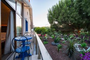 a balcony with two blue chairs and a garden at Lulu Inn Cesme in Çeşme
