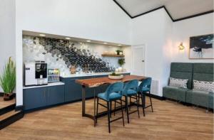 kuchnia ze stołem z niebieskimi krzesłami i stojakami na wino w obiekcie Wyndham 108 Corporate & Modern 1br Suite w mieście Hampton