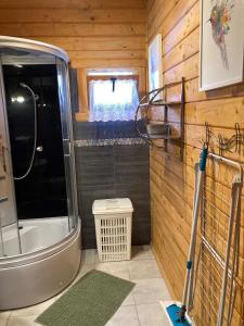 a bathroom with a tub and a shower in a room at Domki Letniskowe w Sercu Natury in Świerkocin +71 photos