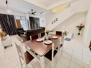 een eetkamer en een woonkamer met een houten tafel en stoelen bij Cozy 10 Entire House 4 Bedroom At Alma Bukit Mertajam in Bukit Mertajam