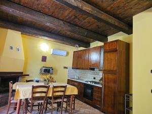 Una cocina con una mesa y algunos armarios de madera. en Agriturismo Ca Serrantonio - Ferri Villetta Mozart, en Urbania