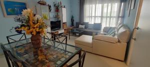 a living room with a couch and a glass table at Apartamento la paz. Un lugar para descansar. in Isla Cristina