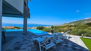 マカルスカにあるVilla La Marのパティオ(テーブル、椅子付)、スイミングプールが備わります。