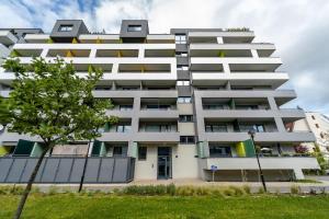 a white apartment building with a tree in front of it at AH Radnica Luxury Spa in Košice