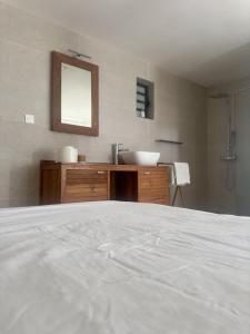 a bathroom with a white bed and a sink at Cozy Caze in Saint-Joseph