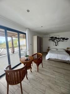 a bedroom with a bed and a table and chairs at Cozy Caze in Saint-Joseph