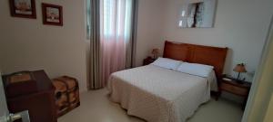 a bedroom with a bed with white sheets and a window at Apartamento la paz. Un lugar para descansar. in Isla Cristina