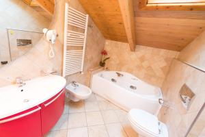 a bathroom with a sink and a tub and a toilet at Hotel Champagne in Livigno +51 photos