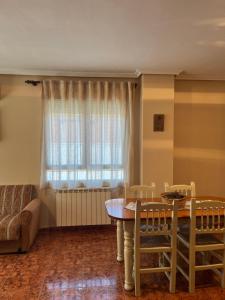 a living room with a table and chairs and a window at Apartamentos Ruidera in Ruidera