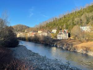 un fiume con case sul fianco di una montagna di Appartement au cœur du village - Les Fougères Tardets a Tardets-Sorholus Altre 8 foto