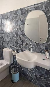 een badkamer met een wastafel en een spiegel en een toilet bij Dendrinos studio in Galissas