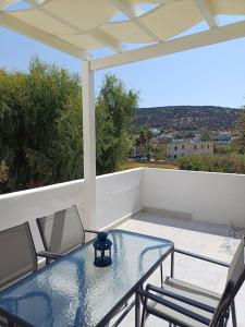 een glazen tafel en stoelen op een balkon met uitzicht bij Dendrinos studio in Galissas