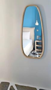 een spiegel in een kamer met een bed en een stoel bij Dendrinos studio in Galissas