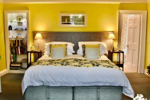 a bedroom with a large bed with yellow walls at Applegarth House in Lockerbie