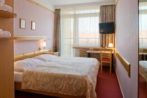 Postel nebo postele na pokoji v ubytování Hotel Akademie a depandance Vila Jarmila