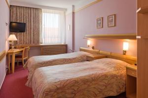 Postel nebo postele na pokoji v ubytování Hotel Akademie a depandance Vila Jarmila