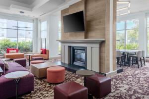 a living room with a fireplace and a tv at Hilton Garden Inn Sarasota-Bradenton Airport in Sarasota
